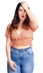 Fototapeta premium Beautiful young brunette woman wearing casual clothes surprised with hand on head for mistake, remember error. forgot, bad memory concept.