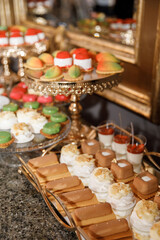 A lovely wedding cake standing among the candy bar. Sweet table. Banquet table. Holiday food. Sweet festive table.