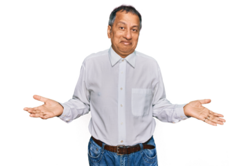 Middle age indian man wearing casual white shirt clueless and confused expression with arms and hands raised. doubt concept.
