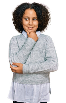 Young little girl with afro hair wearing casual clothes with hand on chin thinking about question, pensive expression. smiling with thoughtful face. doubt concept.