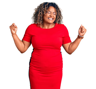 Young african american plus size woman wearing casual clothes very happy and excited doing winner gesture with arms raised, smiling and screaming for success. celebration concept.