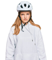 Beautiful young caucasian girl wearing bike helmet with serious expression on face. simple and natural looking at the camera.
