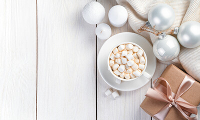 Christmas composition with coffee with marshmallows, a gift and Christmas decorations. The concept of Christmas, New Year. Top view, copy space
