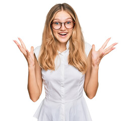 Beautiful young caucasian girl wearing casual clothes and glasses celebrating crazy and amazed for success with arms raised and open eyes screaming excited. winner concept