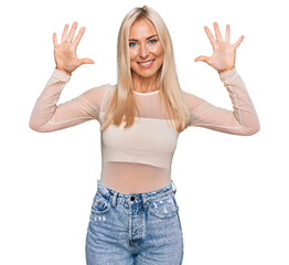Fototapeta na wymiar Young blonde woman wearing casual clothes showing and pointing up with fingers number ten while smiling confident and happy.