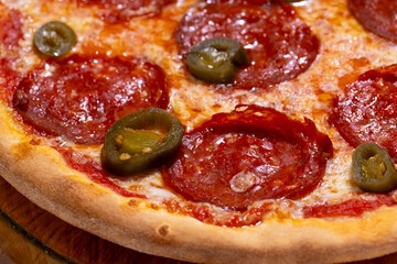 Closeup of pizza with pepperoni and jalapeno pepper