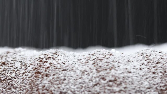 Puderzucker rieselt auf Kuchen