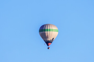 Fototapeta premium A colorful hot air balloon in the morning blue sky over the city of Augsburg