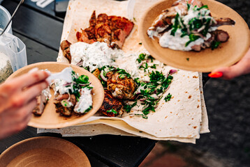 woman hand holding paper plate with meat outdoor