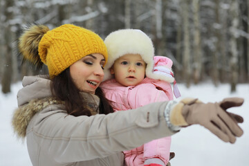 Obraz premium Happy family playing and laughing in winter outdoors in the snow. City park winter day.