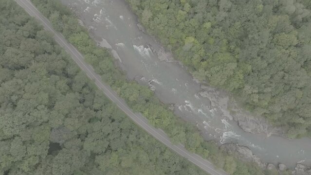 Aerial view of Mountain river and road. Flying over a mountain gorge. ProRes 422, 10 bit ungraded DJI D-LOG video