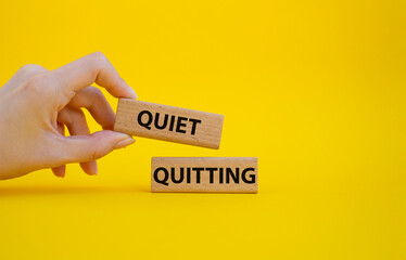 Quiet quitting symbol. Concept word Quiet quitting on wooden blocks. Beautiful yellow background....