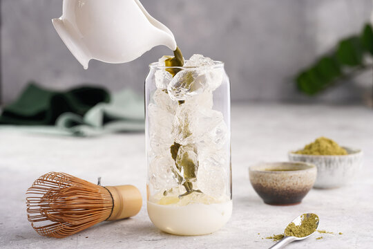 Pouring Matcha Tea Into Tall Boba Tea Glass With Ice And Milk To Make Matcha Latte