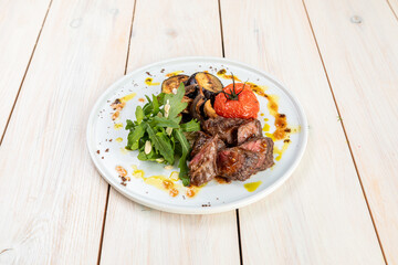 barbecue with grilled vegetables with fresh herbs on a white plate