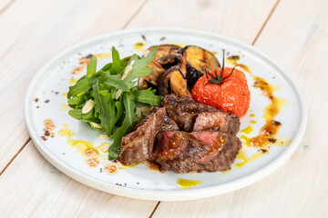 barbecue with grilled vegetables with fresh herbs on a white plate