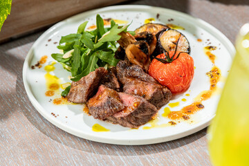 barbecue with grilled vegetables with fresh herbs on a white plate