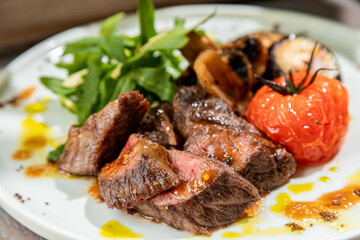 barbecue with grilled vegetables with fresh herbs on a white plate