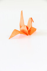 Orange Japanese origami crane on a white background
