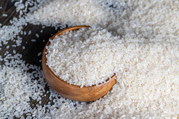a pile of white rice on the kitchen table in a wooden plate