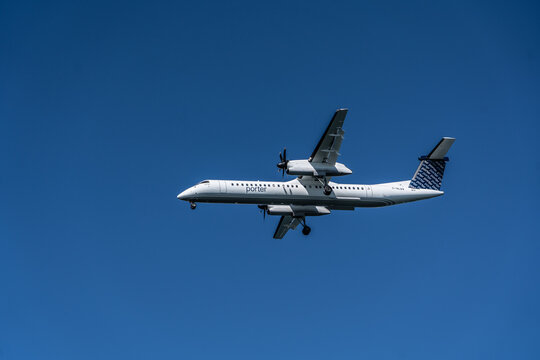 Porter Airlines Turboprop Airplane Dash-8 in-flight is approaching its home base, the Billy Bishop Toronto City Airport