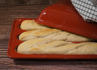 Home made fresh french Baguette loafs in red porcelain mold