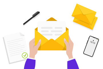 Hands holding an opened envelope. Hands holding letter, surrounded by papers, pen, envelope and phone. Top view on table surface. Sending letter through postal service. Mail delivery and post office
