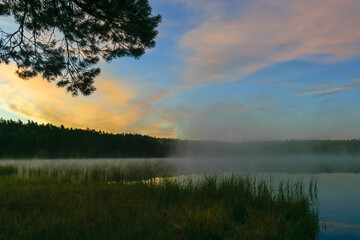 Fototapeta na wymiar sunrise picture with gorgeous sky, fog covers the surface of the lake, sunrise colored sky
