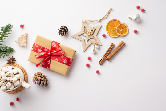 Top view photo of christmas decorations wood star ornaments cup of cocoa with marshmallow pine cones branch craft paper giftbox mistletoe berries cinnamon dried citrus slices isolated white background
