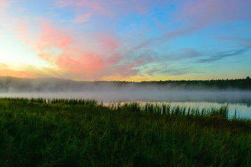 Obraz premium sunrise picture with gorgeous sky, fog covers the surface of the lake, sunrise colored sky