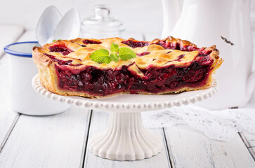 Traditional French cherry pie with fresh fruits served as close-up on a cake plate