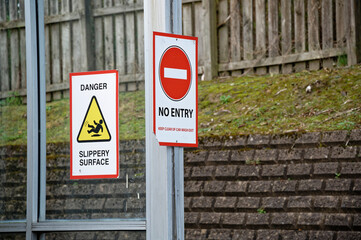 Slippery surface danger sign and no entry sign at car wash