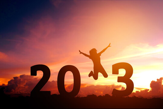 Silhouette young woman jumping to 2023 new year