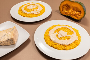 Two plates of traditional Italian Risotto with pumpkin and Gorgonzola cheese