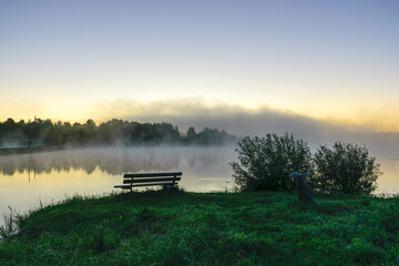 autumn morning by the lake, fog over the surface of the water, a moment before sunrise