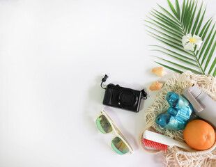 summer holiday concept , beach accessories , palm leaf macrame bag ,  orange , camera on white background , top view, tropical vacation travel concept	
