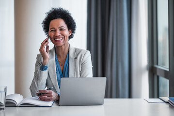 Portrait of confident female businesswoman company director, talking on the phone at the office. - obrazy, fototapety, plakaty