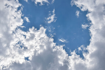 Beautiful cloudy sky. Blue sky with lots of white fluffy clouds, natural background, full frame. Copy space, place for text. Selective focus.