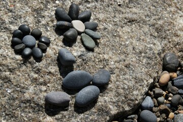 An abstract face made of stones and pebbles.