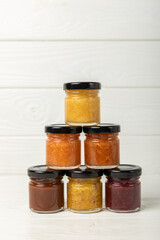 Honey jam with nuts on white texture wood. Assorted honey. Honey in pistachios and almonds. Environmentally friendly product. Vitaminized jam. Cold remedy.Copy space