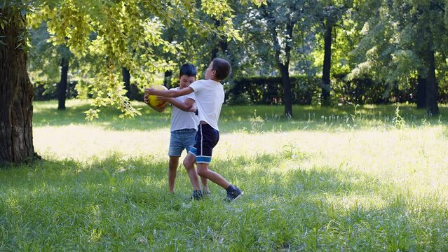 Two asian boys playing ball outdoor. 4k footage.