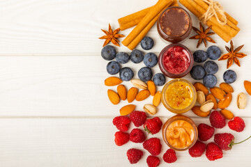 Jar of honey. Fruit honey with raspberries, blueberries, almonds and pistachios. Useful fortified jam for health and beauty. Honey cream. Vegetarian diet organic product. Copy space.