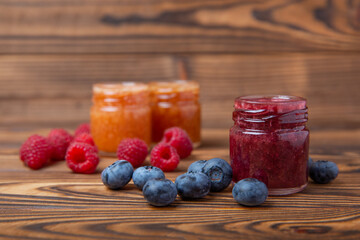 Honey in a glass jar. Raspberry and blueberry honey jam. Remedy for colds and respiratory diseases. Organic product of a vegetarian diet. copy space. copy space