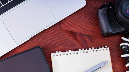 Freelancer's workplace. Laptop, smartphone and notebook on a wooden table. Concept of home office and remote work. Top view