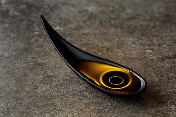 Vegetable oil in small bowl on a stone table.