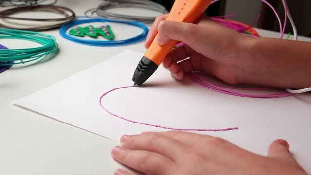 Teen Girl Using 3d Pen. Printing with Colored Plastic Wire Filament. Child making a Heart, drawing with 3D pen. Artwork, Robotics. STEAM, STEM education. Modern Technologies. Play and study at home