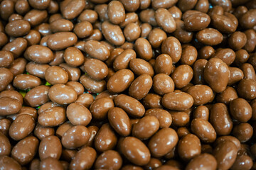 All-over texture of chocolate nuts. Brown Chocolate Covered Peanuts. Nuts as a tasty candy in a candy store.