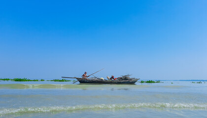 Obraz premium Bangladeshi traditional fishing boat on Meghna river. Fisherman in a small boat on the river.