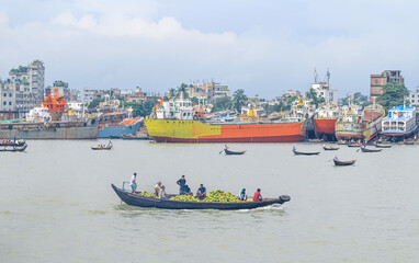Beautiful landscape of Sadarghat river port on Buriganga river in Dhaka. Ferry boats on the river with a cloudy sky background.