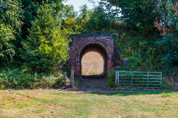 A view towards a tunnel next to the haunted ruins of Grace Dieu Priory in Leicestershire, UK in summertime