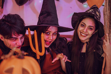Obraz premium Asian young people in costumes celebrating halloween. Group of friends having fun at party in nightclub.